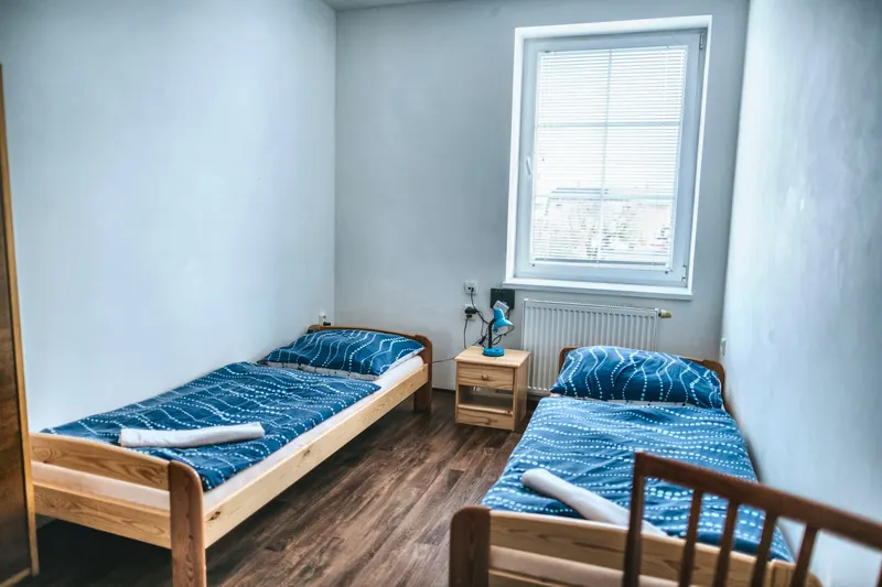 Pokoj se dvěma postelemi a modrým povlečením