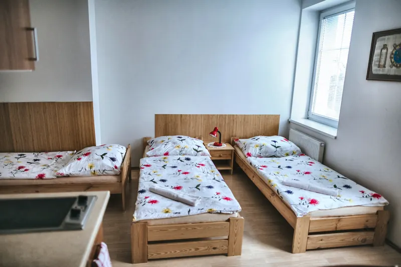 Tři samostatné postele a kuchyňský kout s varnou deskou